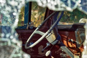A truck wheel seen through a broken window