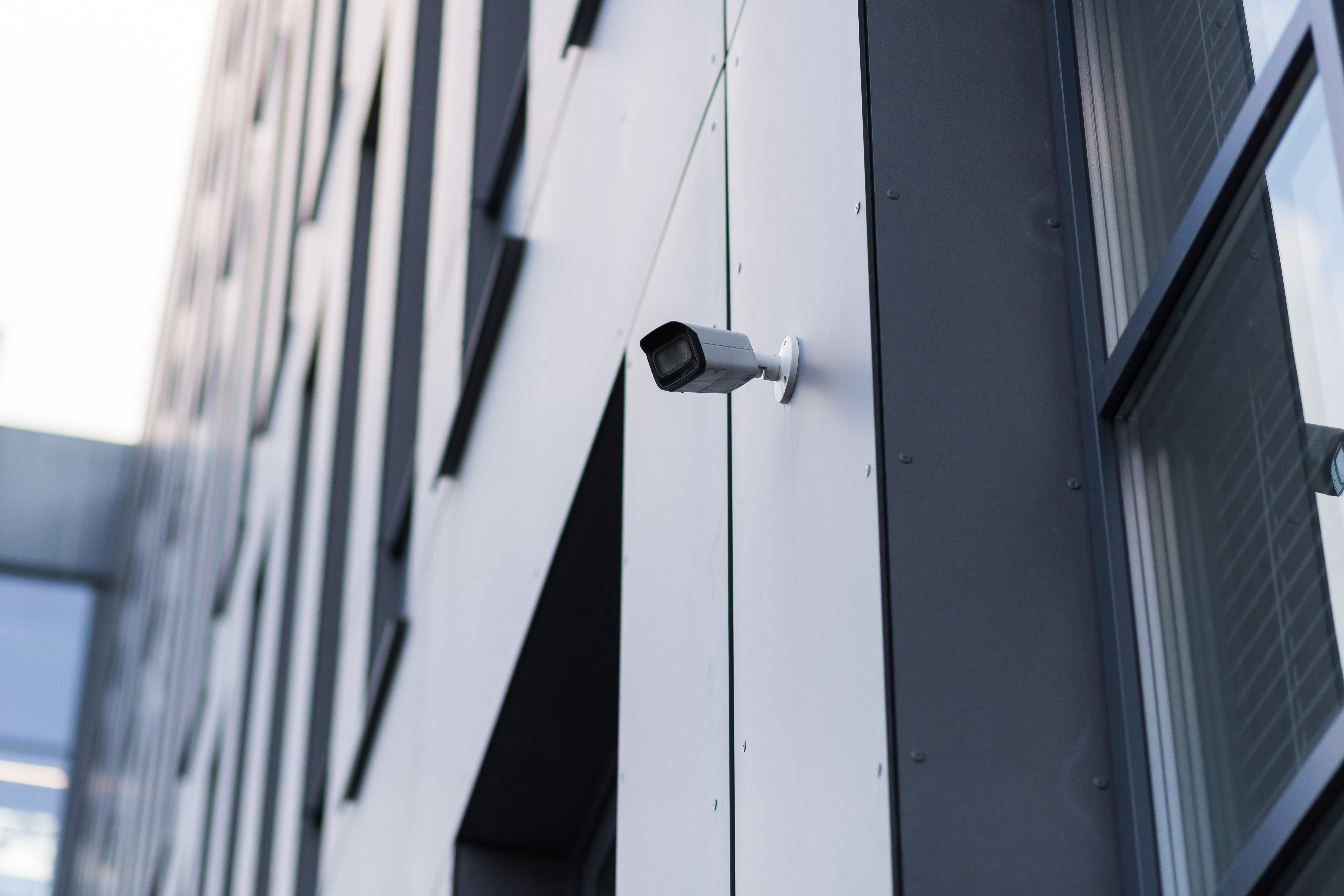 Cámara de seguridad instalada en la esquina de un edificio apuntando hacia una intersección, representando el video que puede probar un accidente de auto en el DMV.